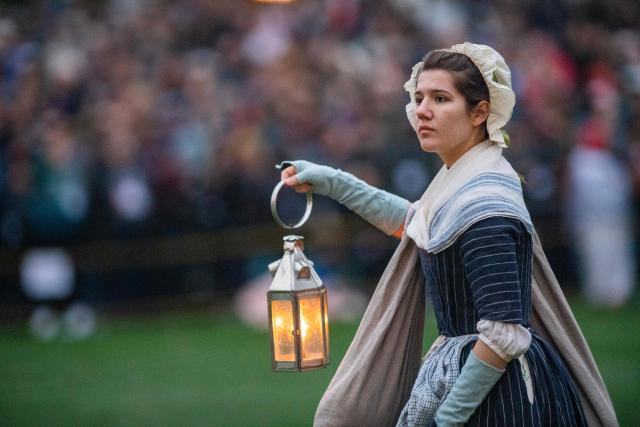 A civilian evacuee reenactor moves across the green during a reenactment of the Battle of Lexington and Concord as part of Patriot's Day celebrations in Lexington, Massachusetts, on April 18, 2026. April 19, 2026 marks the 250th anniversary of the Battle of Lexington and Concord, the first major military actions between the British Army and the Colonial American militias during the American Revolutionary War. (Photo by Joseph Prezioso / AFP)