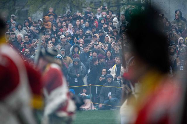 Members of the public watch a reenactment of the Battle of Lexington and Concord as part of Patriot's Day celebrations in Lexington, Massachusetts, on April 18, 2026. April 19, 2026 marks the 250th anniversary of the Battle of Lexington and Concord, the first major military actions between the British Army and the Colonial American militias during the American Revolutionary War. (Photo by Joseph Prezioso / AFP)