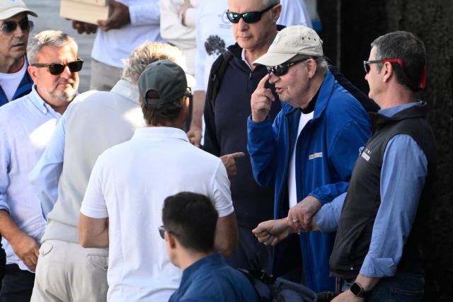 Spain's former King Juan Carlos I (C) arrives at the Royal Yacht Club of Sanxenxo, northern Spain on April 18, 2026. The former head of state, who served as monarch between 1975 and 2014 arrived to attend a regatta. (Photo by Miguel RIOPA / AFP)