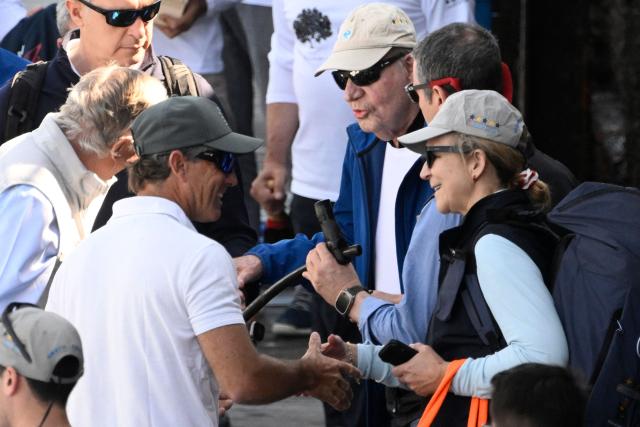 Spain's former King Juan Carlos I (C) and Spain's Princess Elena (R) arrive at the Royal Yacht Club of Sanxenxo, northern Spain on April 18, 2026. The former head of state, who served as monarch between 1975 and 2014 arrived to attend a regatta. (Photo by Miguel RIOPA / AFP)