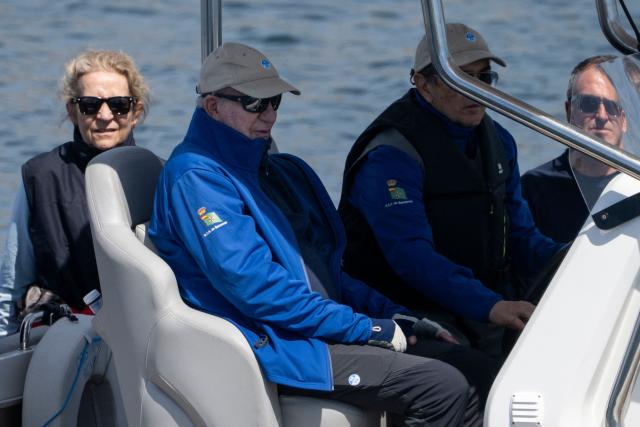Spain's former King Juan Carlos I (C) and Spain's Princess Elena (L) ride aboard a boat at the Royal Yacht Club of Sanxenxo, northern Spain on April 18, 2026. The former head of state, who served as monarch between 1975 and 2014 arrived to attend a regatta. (Photo by Miguel RIOPA / AFP)