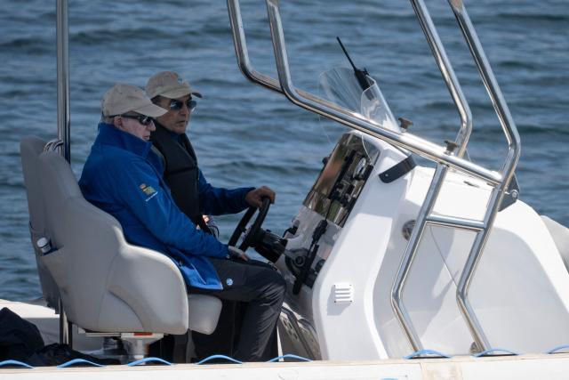 Spain's former King Juan Carlos I (L)  rides aboard a boat in Sanxenxo, northern Spain on April 18, 2026. The former head of state, who served as monarch between 1975 and 2014 arrived to attend a regatta. (Photo by Miguel RIOPA / AFP)
