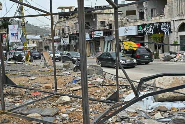 Displaced residents drive past destroyed buildings as they return back to the southern Lebanese city of Nabatieh on April 18, 2026. Lebanese President Joseph Aoun said on April 17 that his country was on the verge of a "new phase" of "permanent agreements", after the 10-day ceasefire in the Israel-Hezbollah war went into force. Lebanon was drawn into the Middle East conflict on March 2 when Tehran-backed Hezbollah attacked Israel to avenge the death of Iranian supreme leader Ali Khamenei. (Photo by FADEL itani / AFP)