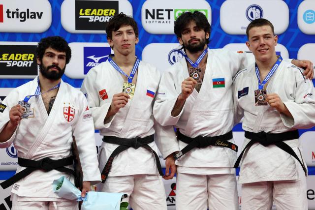 Silver medallist Georgia's Tato Grigalashvili, gold medallist Russia's Timur Arbuzov and bronze medallists Azerbaijan's Zelim Tckaev and Serbia's Mihajlo Simin celebrate on the podium for the men's under 81 kg category event at the Judo European Senior Championships 2026 in Tbilisi on April 18, 2026. (Photo by Giorgi ARJEVANIDZE / AFP)