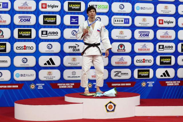 Gold medallist Russia's Timur Arbuzov celebrates on the podium for the men's under 81 kg category event at the Judo European Senior Championships 2026 in Tbilisi on April 18, 2026. (Photo by Giorgi ARJEVANIDZE / AFP)