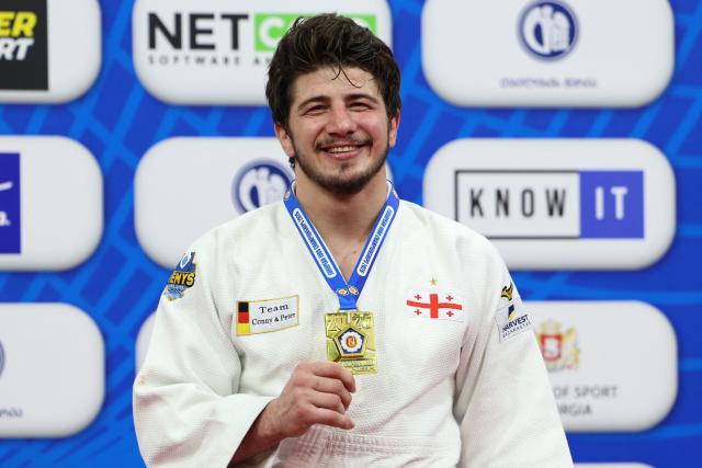 Gold medallist Georgia's Luka Maisuradze celebrates on the podium for the men's under 90 kg category event at the Judo European Senior Championships 2026 in Tbilisi on April 18, 2026. (Photo by Giorgi ARJEVANIDZE / AFP)