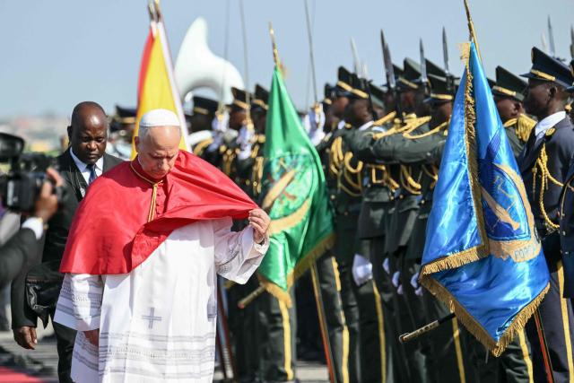 Pope Leo XIV fixes his pellegrina as he arrives at the "4 de Fevereiro" Luanda International Airport in Luanda on the sixth day of an 11-day apostolic journey to Africa, on April 18, 2026. (Photo by Alberto PIZZOLI / AFP)