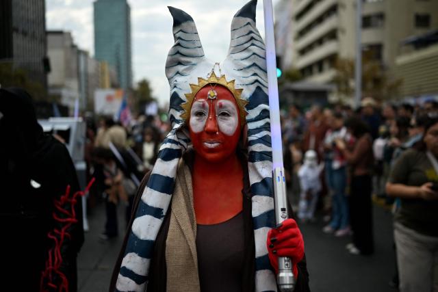 A fan wearing a costume from the Star Wars films takes part in the Desfile de las Galaxias 2026 in Santiago on April 18, 2026. (Photo by RODRIGO ARANGUA / AFP)