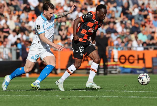 Lorient's Cameroonian midfielder #62 Arthur Avom Ebong (R) fights for the ball with Marseille's Danish midfielder #23 Pierre-Emile Hojbjerg (L) during the French L1 football match between FC Lorient and Olympique de Marseille at the Moustoir stadium in Lorient, western France on April 18, 2026. (Photo by Fred TANNEAU / AFP)