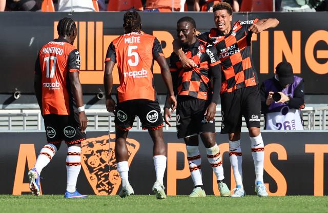 Lorient's Senegalese forward Bamba Dieng #12 (2nd R) celebrates with teammates after scoring his team second goal during the French L1 football match between FC Lorient and Olympique de Marseille at the Moustoir stadium in Lorient, western France on April 18, 2026. (Photo by Fred TANNEAU / AFP)