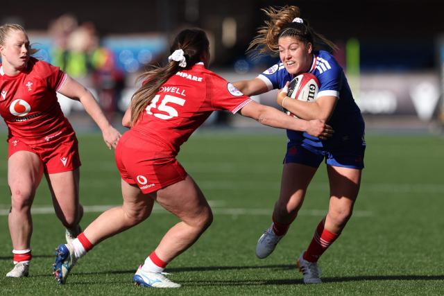 France's full-back Pauline Barrat (R) is tackled by Wales' full-back Kayleigh Powell (C) during the Women's Six Nations international rugby union match between Wales and France  at the Cardiff Arms Park, in Cardiff, southern Wales on April 18, 2026. (Photo by Adrian Dennis / AFP)