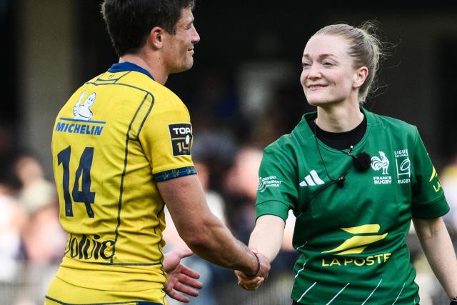 Scottish referee Hollie Davidson (C) shakes hands with Clermont’s Argentine wing #14 Bautista Delguy (L) at the end of the French Top14 rugby union match between ASM Clermont Auvergne and Lyon Olympique Universitaire Rugby at the Marcel-Michelin Stadium in Clermont-Ferrand, central France on April 18, 2026. (Photo by ARNAUD FINISTRE / AFP)