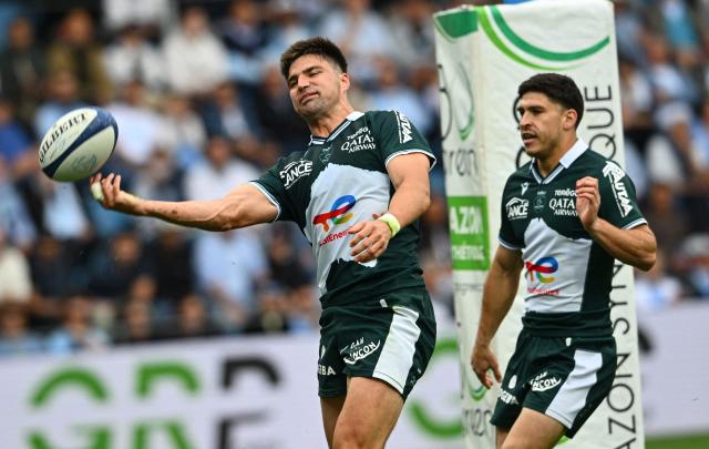 Pau's Australian fullback Jack Maddocks (L) throws the ball after scoring a try during the French Top14 rugby union match between Aviron Bayonnais (Bayonne) and  Section Paloise (Pau) at the Jean Dauger stadium in Bayonne, south-western France on April 18, 2026. (Photo by Gaizka IROZ / AFP)