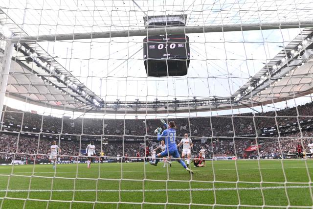 Leipzig's Belgian goalkeeper #26 Maarten Vandevoordt (C) goes to save the ball as Frankfurt's German forward #09 Jonathan Burkardt (R) looks on during the German first division Bundesliga football match between Eintracht Frankfurt and RB Leipzig in Frankfurt am Main, western Germany, on April 18, 2026. (Photo by Kirill KUDRYAVTSEV / AFP) / DFL REGULATIONS PROHIBIT ANY USE OF PHOTOGRAPHS AS IMAGE SEQUENCES AND/OR QUASI-VIDEO