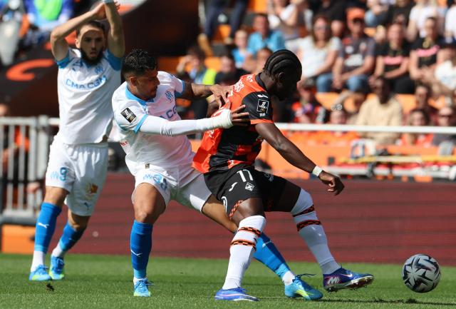 Lorient's French midfielder #17 Jean-Victor Makengo (R) fights for the ball with Marseille's Italian defender #33 Emerson Palmieri (C) during the French L1 football match between FC Lorient and Olympique de Marseille at the Moustoir stadium in Lorient, western France on April 18, 2026. (Photo by Fred TANNEAU / AFP)