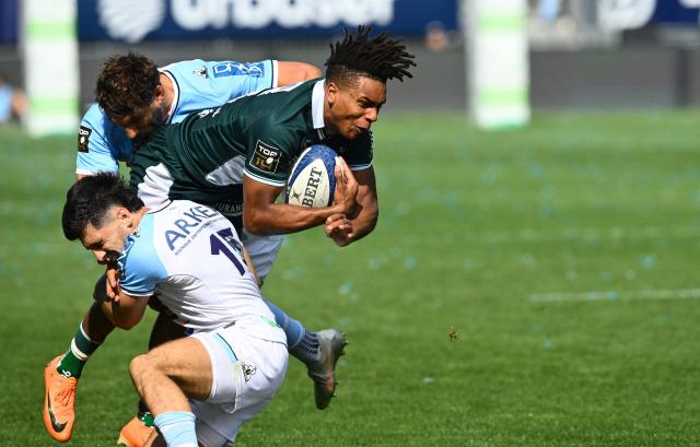 Pau's French winger Theo Attissogbe (R) is tackled during the French Top14 rugby union match between Aviron Bayonnais (Bayonne) and  Section Paloise (Pau) at the Jean Dauger stadium in Bayonne, south-western France on April 18, 2026. (Photo by Gaizka IROZ / AFP)
