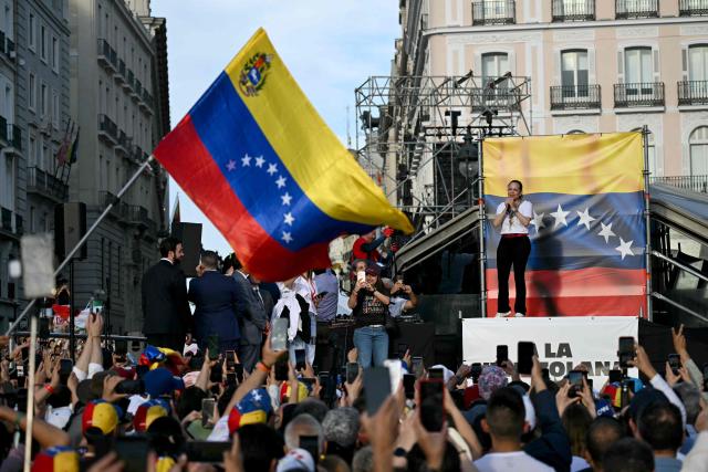 Venezuelan opposition leader Maria Corina Machado gestures on stage in front of supporters in Madrid's Puerta del Sol on April 18, 2026. Spain's right-wing parties showed their support for Venezuelan opposition figure and Nobel Peace Prize winner Maria Corina Machado who  turned down a meeting with the country's leftist PM, considering it 'unsuitable' for the moment. (Photo by Javier SORIANO / AFP)