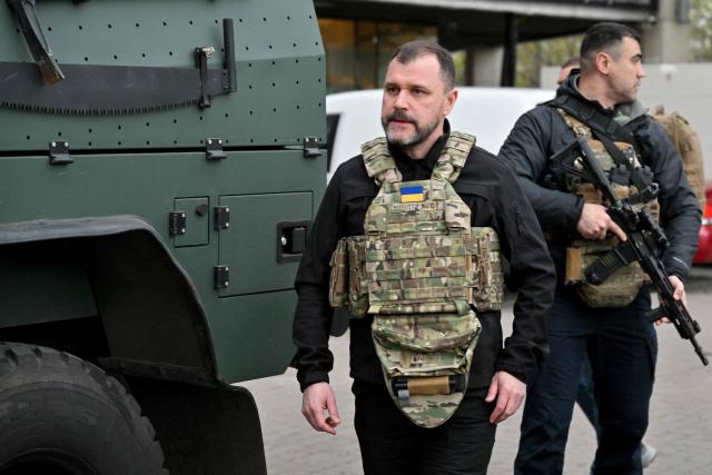 Ukraine's Minister of Internal Affairs Igor Klimenko walks outside a supermarket following a shooting in Kyiv on April 18, 2026. A gunman opened fire in Kyiv on April 18, 2026, killing at least five people, wounding others and taking hostages at a supermarket before being killed during an arrest attempt, officials said. Ukrainian President said that at least five people were dead and 10 hospitalised with wounds and trauma after the shooting in a residential district of the capital. (Photo by Sergei SUPINSKY / AFP)