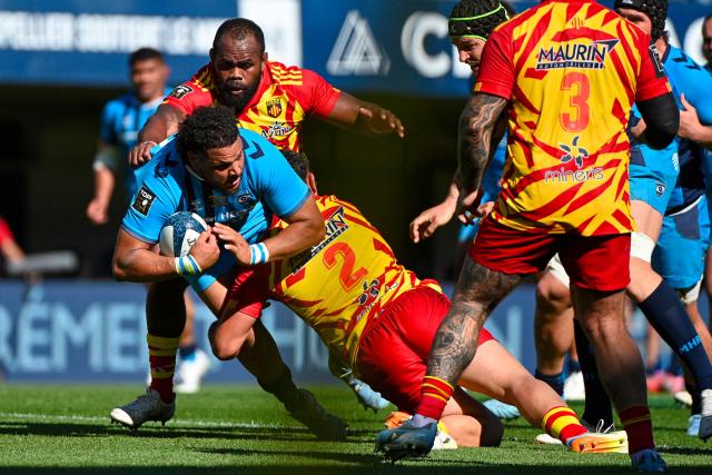 Montpellier's French prop Mohamed Haouas (C) is tackled during the French Top14 rugby union match between Montpellier Herault Rugby and USA Perpignan at the Septeo Stadium in Montpellier, southern France on April 18, 2026. (Photo by Sylvain THOMAS / AFP)