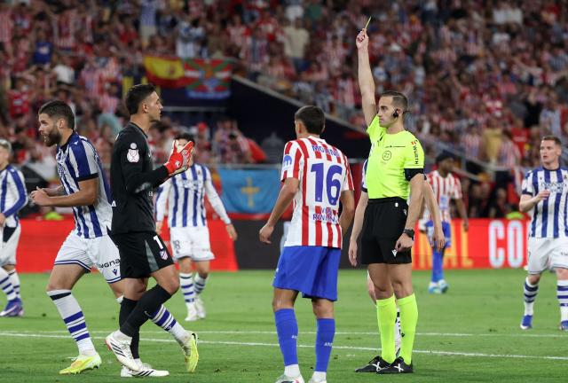 Atletico Madrid's Argentine goalkeeper #01 Juan Musso is shown a yellow card by Spanish referee Javier Alberola Rojas during the Copa del Rey (King's Cup) final football match between Club Atletico de Madrid and Real Sociedad at La Cartuja stadium in Seville on April 18, 2026. (Photo by Thomas COEX / AFP)