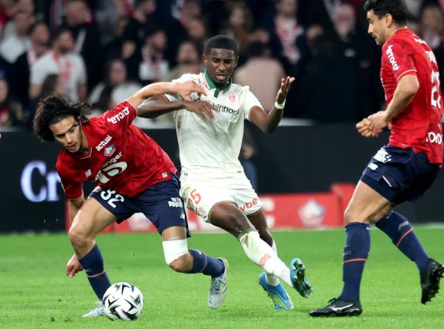 Lille's French midfielder #32 Ayyoub Bouaddi (L) vies with Nice's French forward #25 Mohamed-Ali Cho (C) during the French L1 football match between Lille OSC and OGC Nice at the Pierre Mauroy stadium in Villeneuve-d'Ascq, northern France, on April 18, 2026. (Photo by Francois LO PRESTI / AFP)