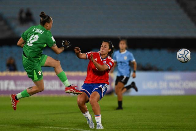Uruguay's goalkeeper #12 Agustina Sanchez kicks the ball past Chile's forward #09 Sonya Keefe during the CONMEBOL Nations League Women football match between Uruguay and Chile at the Centenario stadium in Montevideo, on April 18, 2026. (Photo by Eitan ABRAMOVICH / AFP)