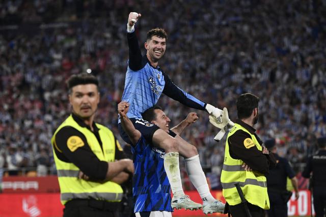 Real Sociedad's Spanish goalkeeper #13 Unai Marrero and Real Sociedad's Spanish forward #10 Mikel Oyarzabal celebrate victory at the end the Copa del Rey (King's Cup) final football match between Club Atletico de Madrid and Real Sociedad at La Cartuja stadium in Seville on April 18, 2026. (Photo by CRISTINA QUICLER / AFP)
