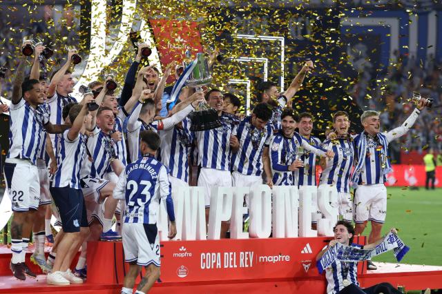 Real Sociedad's Spanish forward #10 Mikel Oyarzabal (C) and teammates celebrate with the trophy at the end the Copa del Rey (King's Cup) final football match between Club Atletico de Madrid and Real Sociedad at La Cartuja stadium in Seville on April 18, 2026. Real Sociedad won Atletico Madrid 4-3 on penalties. (Photo by Thomas COEX / AFP)