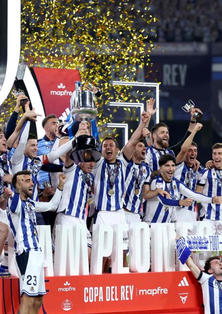 Real Sociedad's players celebrate with the trophy at the end the Copa del Rey (King's Cup) final football match between Club Atletico de Madrid and Real Sociedad at La Cartuja stadium in Seville on April 18, 2026. Real Sociedad won Atletico Madrid 4-3 on penalties. (Photo by Thomas COEX / AFP)