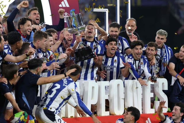 TOPSHOT - Real Sociedad's Spanish forward #10 Mikel Oyarzabal (C) and teammates celebrate with the trophy at the end the Copa del Rey (King's Cup) final football match between Club Atletico de Madrid and Real Sociedad at La Cartuja stadium in Seville on April 18, 2026. Real Sociedad won Atletico Madrid 4-3 on penalties. (Photo by Thomas COEX / AFP)