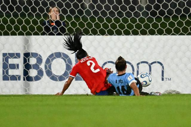 Chile's defender #02 Michelle Olivares Acevedo scores her team's second goal past Uruguay's forward #14 Alaides Bonilla Paz during the CONMEBOL Nations League Women football match between Uruguay and Chile at the Centenario stadium in Montevideo, on April 18, 2026. (Photo by Eitan ABRAMOVICH / AFP)