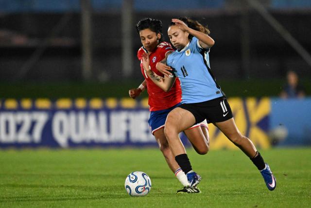 Chile's defender #17 Fernanda Pinilla (L) and Uruguay's forward #11 Esperanza Pizarro (R) fight for the ball during the CONMEBOL Nations League Women football match between Uruguay and Chile at the Centenario stadium in Montevideo, on April 18, 2026. (Photo by Eitan ABRAMOVICH / AFP)