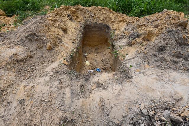A view of an open grave at the cemetery of Cumuto, Trinidad and Tobago, taken on April 18, 2026. The remains of at least 50 infants and six adults were discovered on April 18, 2026, after they had apparently been discarded at a cemetery in Trinidad and Tobago, police said. (Photo by Curtis Chase / AFP)