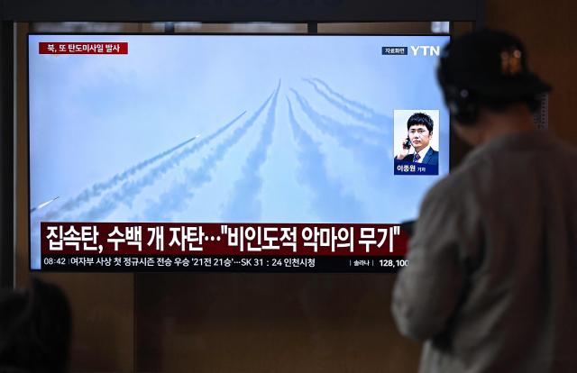 A man watches a television screen showing a news broadcast with file footage of a North Korean missile test, at a train station in Seoul on April 19, 2026. North Korea test-fired multiple ballistic missiles on April 19, South Korea's military said, the latest in a recent flurry of launches by the nuclear-armed state. (Photo by Jung Yeon-je / AFP)