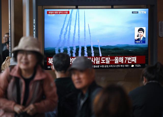 People watch a television screen showing a news broadcast with file footage of a North Korean missile test, at a train station in Seoul on April 19, 2026. North Korea test-fired multiple ballistic missiles on April 19, South Korea's military said, the latest in a recent flurry of launches by the nuclear-armed state. (Photo by Jung Yeon-je / AFP)