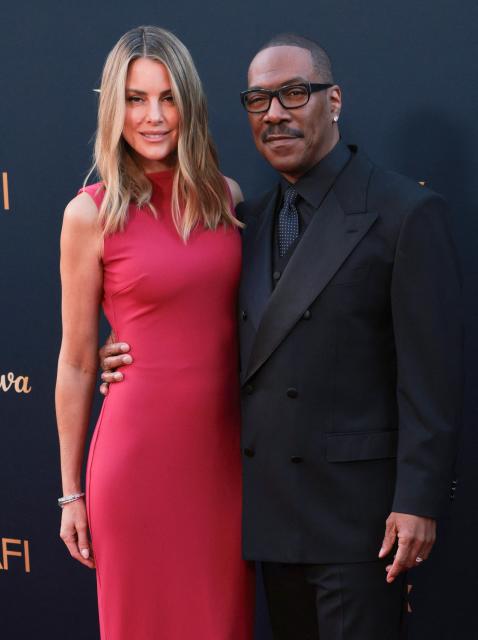 US actor Eddie Murphy and his wife Australian actress Paige Butcher attend the 2026 AFI Life Achievement Award at the Dolby Theatre in Hollywood, California on April 18, 2026. US actor Eddie Murphy is the recipient of the 2026 AFI Life Achievement Award. (Photo by Etienne LAURENT / AFP)
