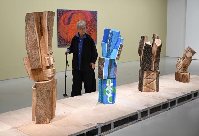 This picture taken on March 11, 2026, shows South Korean sculptor Kim Yun Shin looking at her works in her retrospective exhibition, titled "Two Be One", at Hoam Museum of Art in Yongin. In her 90s, South Korean sculptor Kim Yun Shin still wields a chainsaw with quiet focus, refining a craft she honed over decades spent far away from home. (Photo by Jung Yeon-je / AFP) / TO GO WITH AFP STORY  SKorea-Art BY Claire LEE