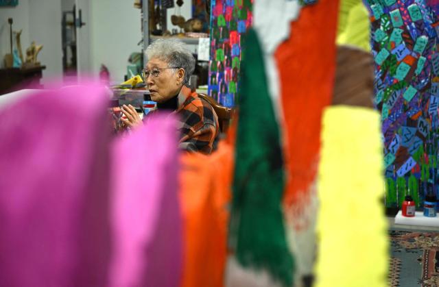 This picture taken on March 4, 2026, shows South Korean sculptor Kim Yun Shin speaking during an interview with AFP at her studio in Paju. In her 90s, South Korean sculptor Kim Yun Shin still wields a chainsaw with quiet focus, refining a craft she honed over decades spent far away from home. (Photo by Jung Yeon-je / AFP) / TO GO WITH AFP STORY  SKorea-Art BY Claire LEE