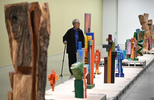 This picture taken on March 11, 2026, shows South Korean sculptor Kim Yun Shin looking at her works in her retrospective exhibition, titled "Two Be One", at Hoam Museum of Art in Yongin. In her 90s, South Korean sculptor Kim Yun Shin still wields a chainsaw with quiet focus, refining a craft she honed over decades spent far away from home. (Photo by Jung Yeon-je / AFP) / TO GO WITH AFP STORY  SKorea-Art BY Claire LEE