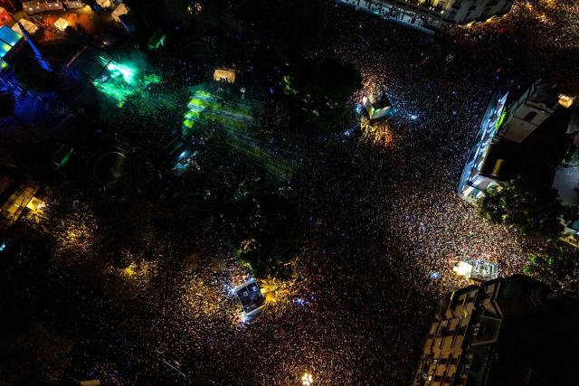 This aerial view shows people attending Portuguese priest and DJ Padre Guilherme's performance during a free electronic music event in Plaza de Mayo, Buenos Aires on April 18, 2026, held in tribute to Pope Francis on the first anniversary of his death. (Photo by Tomas CUESTA / AFP)