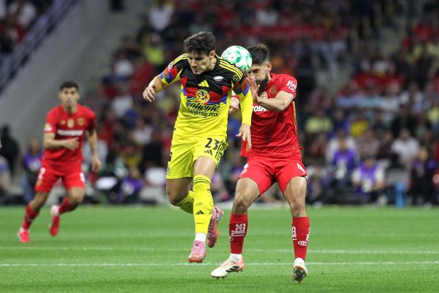 America's Brazilian midfielder #23 Raphael Veiga (L) and Toluca's Uruguayan defender #04 Bruno Mendez (R) fight for the ball during the Liga MX Clausura tournament football match between America and Toluca at the Azteca Stadium in Mexico City on April 18, 2026. (Photo by Victor CRUZ / AFP)