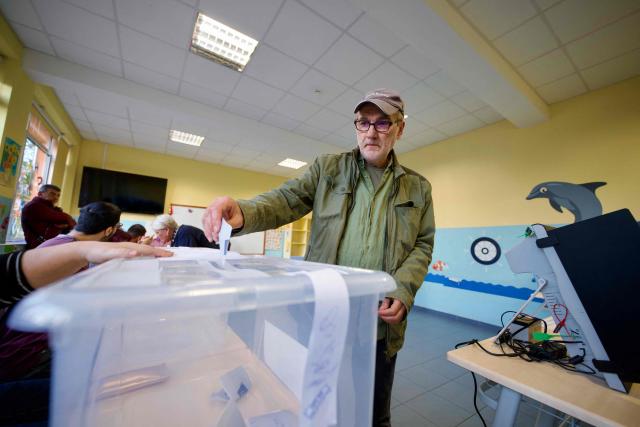 A voter casts his ballot at a polling station during the country's parliamentary elections in Sofia on April 19, 2026. Bulgarians began voting in the eighth election in five years on April 19, with ex-president Rumen Radev's grouping expected to win on a pledge to fight corruption. (Photo by Dimitar KYOSEMARLIEV and Dimitar KYOSEMARLIEV / AFP)