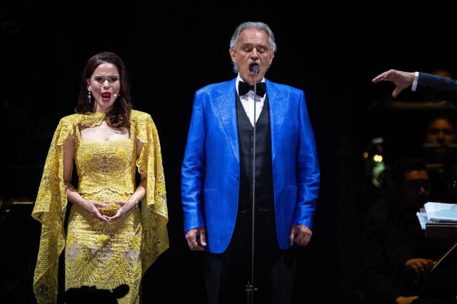 Italian tenor classical musician Andrea Bocelli (R) and Puerto Rican soprano Larisa Martinez (L) perform on stage during a free concert at the Zocalo square in Mexico City on April 18, 2026. (Photo by Carl DE SOUZA / AFP)