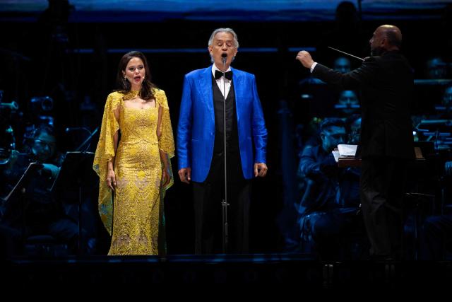 Italian tenor classical musician Andrea Bocelli (R) and Puerto Rican soprano Larisa Martinez (L) perform on stage during a free concert at the Zocalo square in Mexico City on April 18, 2026. (Photo by Carl DE SOUZA / AFP)
