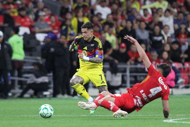 America's Uruguayan midfielder #07 Brian Rodriguez and Toluca's Uruguayan defender #04 Bruno Mendez fight for the ball during the Liga MX Clausura tournament football match between America and Toluca at the Azteca Stadium in Mexico City on April 18, 2026. (Photo by Victor CRUZ / AFP)
