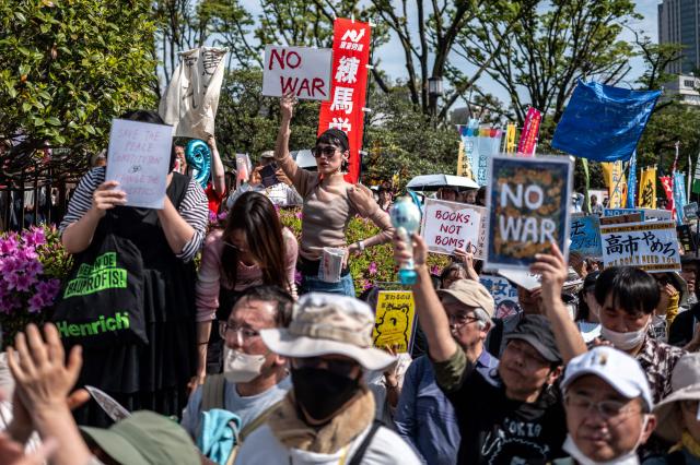 People take part in a "No war! Don’t change the Constitution!" rally outside the main gate of the National Diet Building, to call for the protection of Article 9 of the Constitution of Japan, in Tokyo on April 19, 2026. Article 9 is a clause stipulating that the Japanese people have renounced war as a sovereign right of the nation and the threat or use of force as means of settling international disputes (Photo by Philip FONG / AFP)