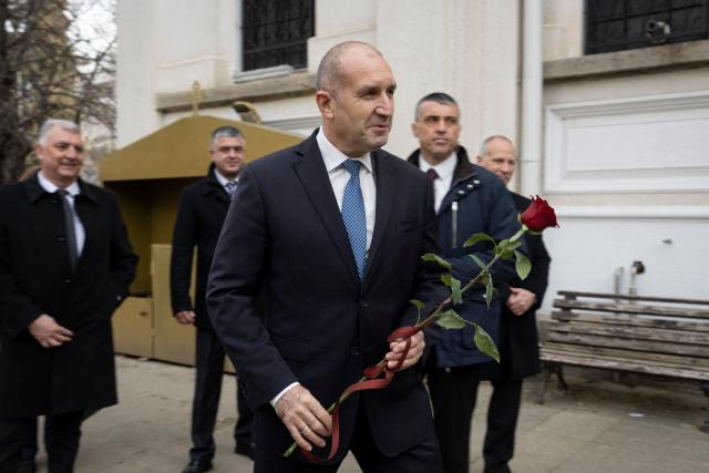 (FILES) Former Bulgaria's President Rumen Radev (C) holds a rose prior a procession in honnor of the Bulgaria’s Liberation Day at the Defenders of Stara Zagora Memorial Complex in Stara Zagora on March 3, 2026. The 62-year-old former fighter pilot, who presents himself as a defender of the most disadvantaged, appears in the eyes of many voters as the providential figure capable of offering Bulgaria a fresh start. (Photo by Nikolay DOYCHINOV / AFP)