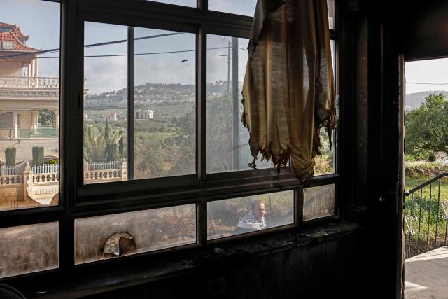 A Palestinian man walks past a burnt house following a reported attack by Israeli settlers in Turmus Ayya village, north of Ramallah in the Israeli-occupied West Bank on April 19, 2026. Violence in the West Bank, which Israel has occupied since 1967, has risen sharply since the October 7, 2023 Hamas attack on Israel triggered the Gaza war. There has also been a spike in deadly attacks by Israeli settlers in the West Bank since the start of the Iran war on February 28, Palestinian authorities and the United Nations have said. (Photo by Zain JAAFAR / AFP)
