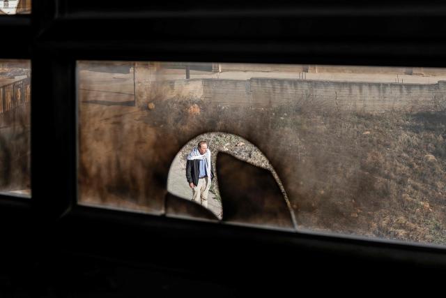 A Palestinian man walks past a burnt house following a reported attack by Israeli settlers in Turmus Ayya village, north of Ramallah in the Israeli-occupied West Bank on April 19, 2026. Violence in the West Bank, which Israel has occupied since 1967, has risen sharply since the October 7, 2023 Hamas attack on Israel triggered the Gaza war. There has also been a spike in deadly attacks by Israeli settlers in the West Bank since the start of the Iran war on February 28, Palestinian authorities and the United Nations have said. (Photo by Zain JAAFAR / AFP)
