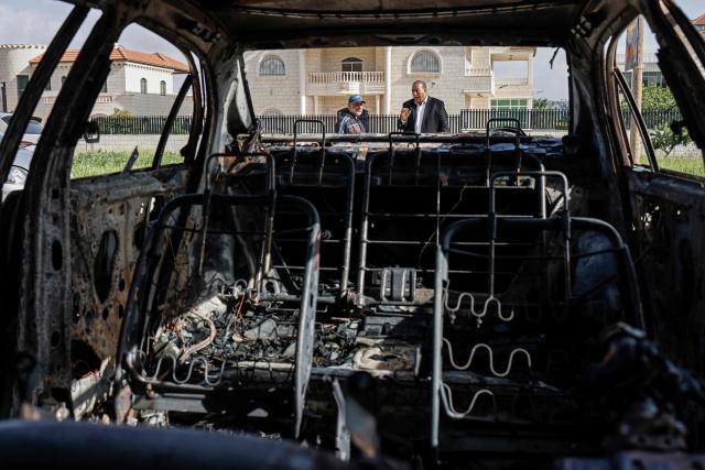 Palestinian men inspect a burnt car following a reported attack by Israeli settlers in Turmus Ayya village, north of Ramallah in the Israeli-occupied West Bank on April 19, 2026. Violence in the West Bank, which Israel has occupied since 1967, has risen sharply since the October 7, 2023 Hamas attack on Israel triggered the Gaza war. There has also been a spike in deadly attacks by Israeli settlers in the West Bank since the start of the Iran war on February 28, Palestinian authorities and the United Nations have said. (Photo by Zain JAAFAR / AFP)